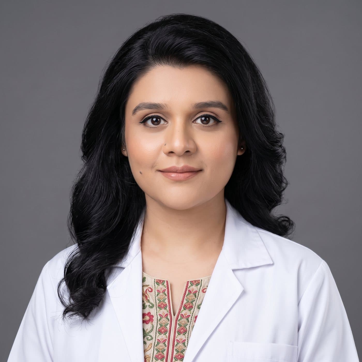 Dr. Anum Abbas, MBBS, Aesthetic Physician, in a white coat